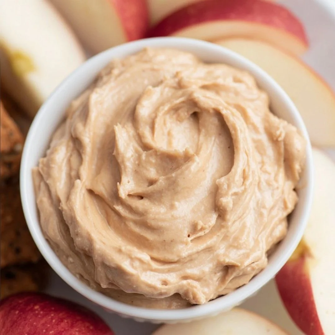 Creamy peanut butter dip served with apple slices and pretzels