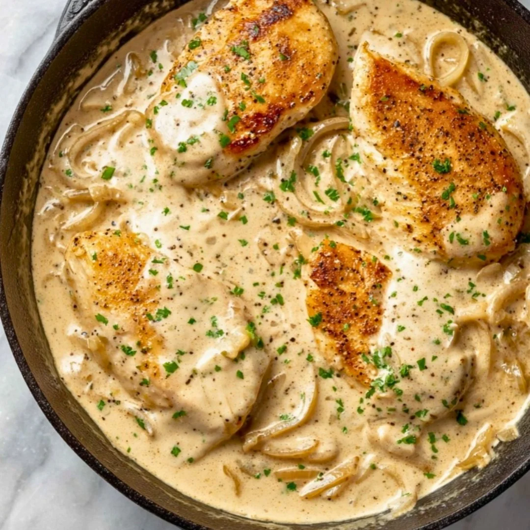 Sour cream onion chicken on a plate garnished with herbs.