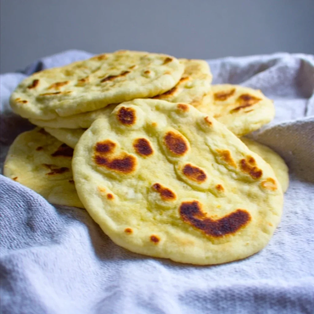 A bright, fizzy blue beverage with granulated salt crystals and a clear jar on a granite surface.