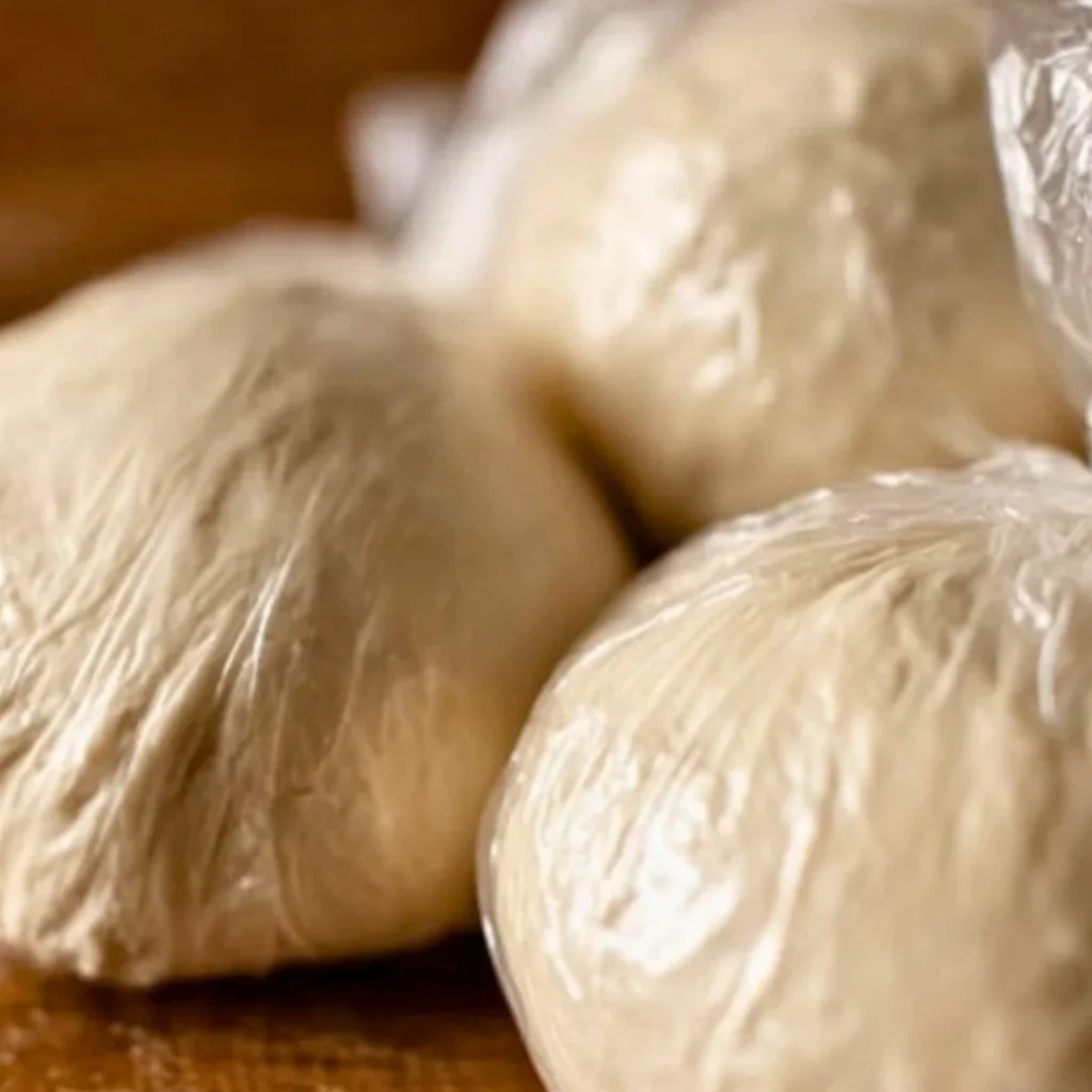 A bright, fizzy blue beverage with granulated salt crystals and a clear jar on a granite surface.